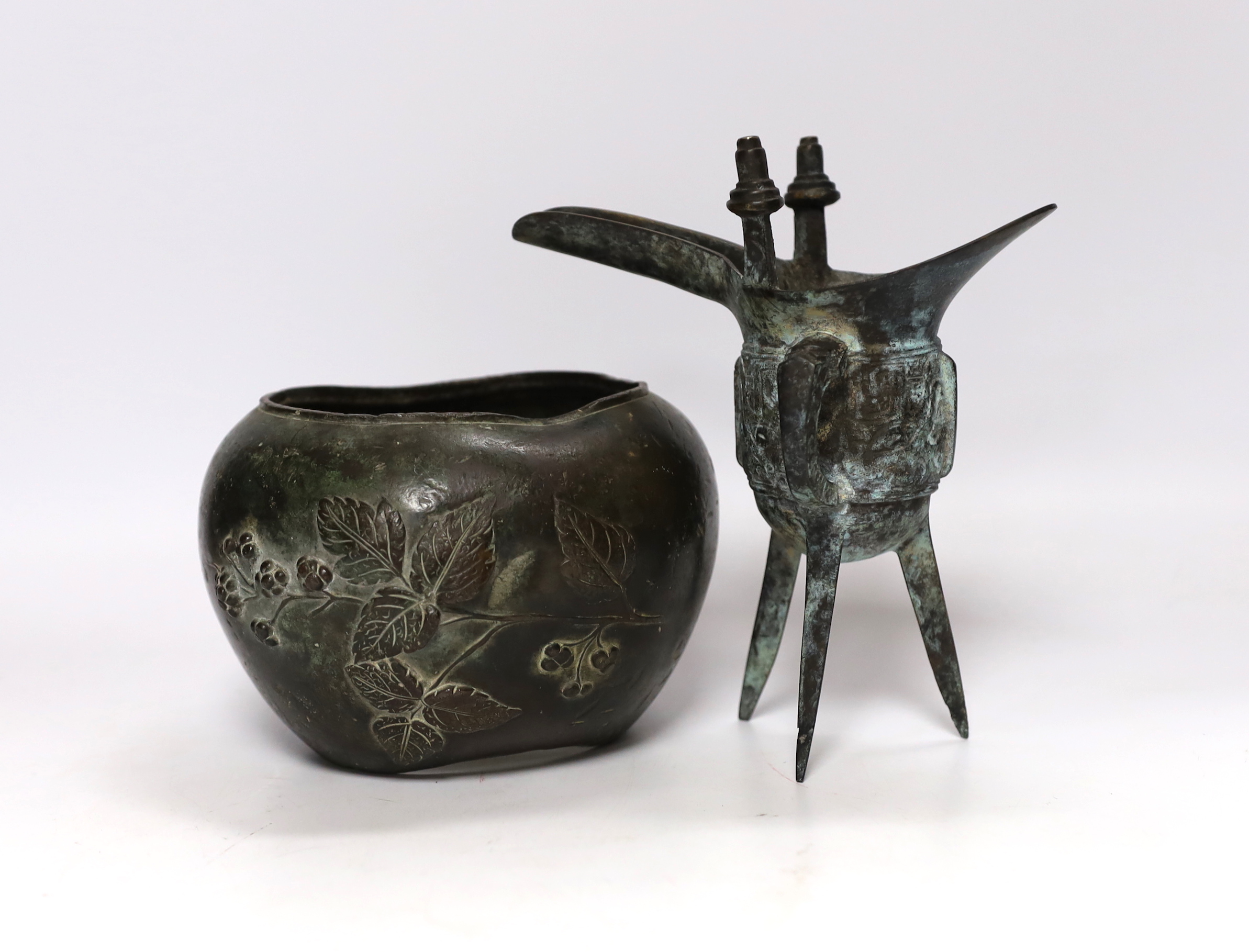 Three Chinese bronze items including a mirror back and a three footed cup, largest 18cm high